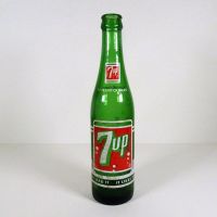 Vintage Seven Up soda bottle with the seven bubble logo. Green glass with red and white ACL graphics: Front - Click to enlarge