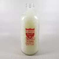 Olbrych's Dairy vintage clear glass acl one quart milk bottle with red graphics and textured body: Front - Click to enlarge