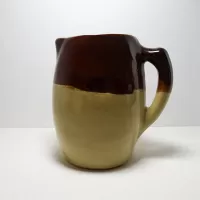 Antique glazed stoneware pitcher with handle. Brown top, beige bottom, band of a third color separating them: Left - Click to enlarge
